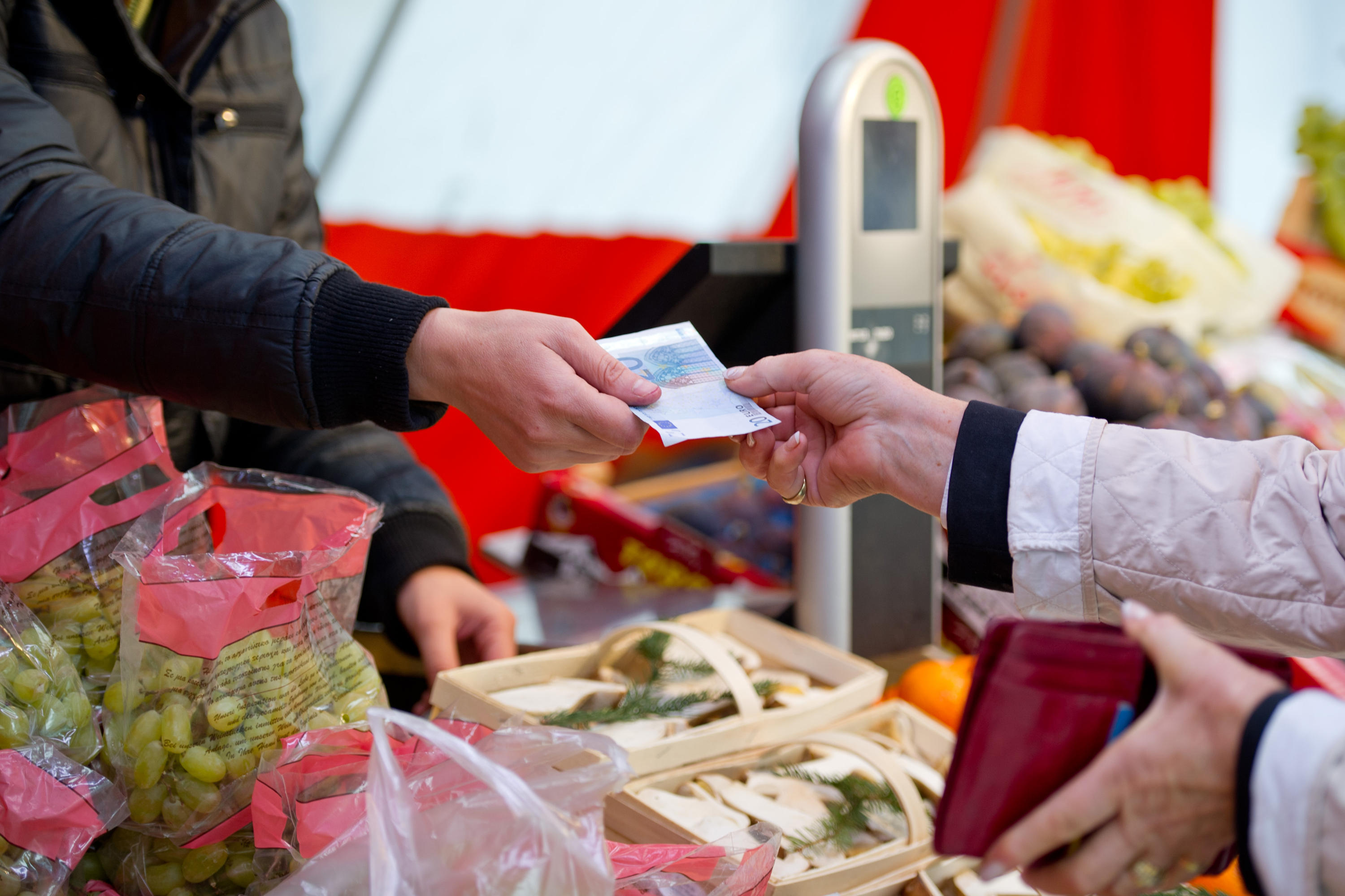 Barzahlung mit einer 20-Euro-Banknote an einem Marktstand