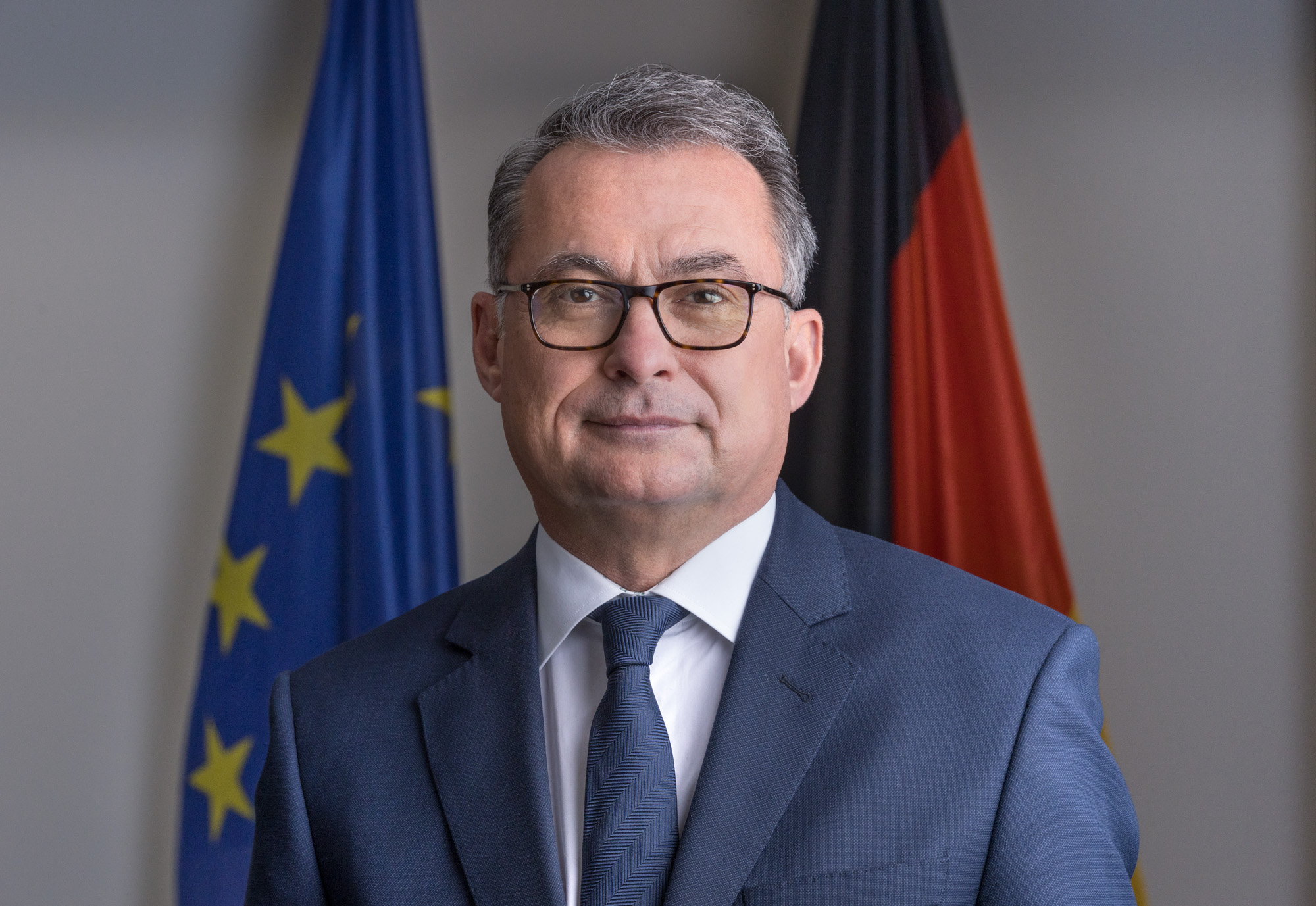 Portrait von Joachim Nagel; im Hintergrund die Europa- und die Deutschlandflagge